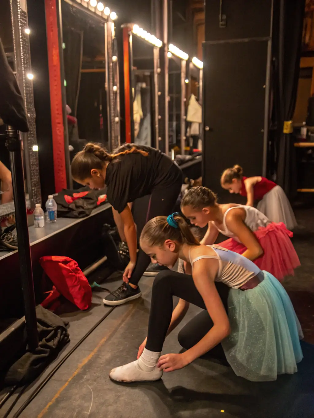 A photo of dancers backstage preparing for a performance, showing the dedication and teamwork involved in bringing a show to life.